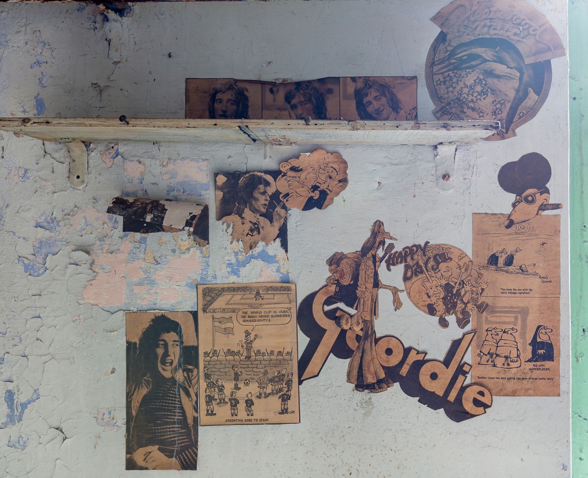 Old newspaper cuttings stuck to the walls