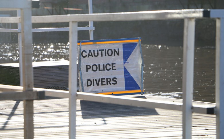 A sign warns of the work of the police underwater unit on the bank of the Ouse