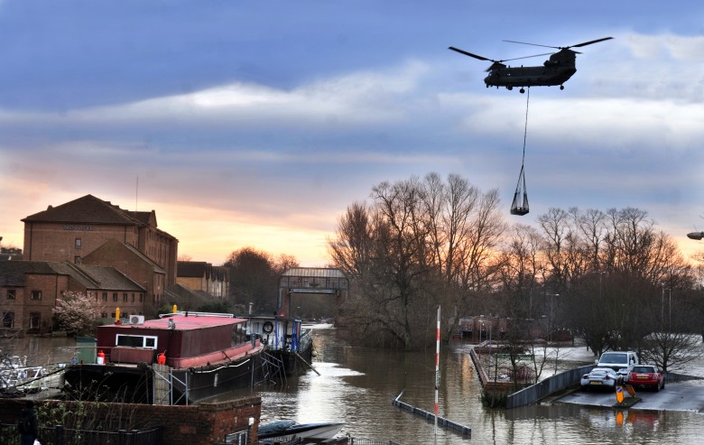 A Chinook helicopter hovers above Castle Mills Bridge in York as he delivers parts to repair the Foss barrier which failed causing widespread flooding in the city.Pic : Nigel Holland