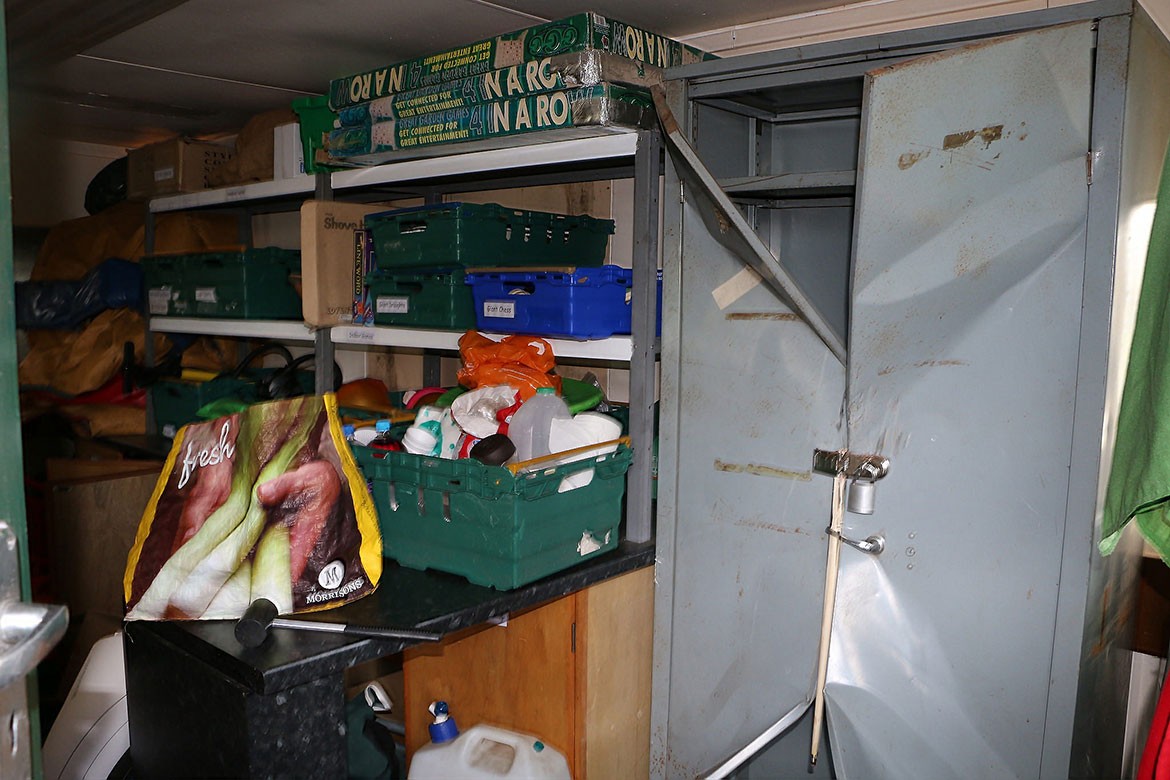 Inside one of the buildings a metal cupboard is attacked and the contents trashed