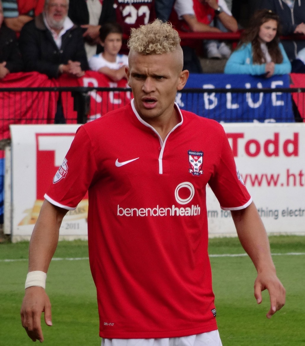 Still on his feet in this picture – Lindon Meikle in action for York City against against Northampton Town at Bootham Crescent. Photograph © Mattythewhite on Wikipedia