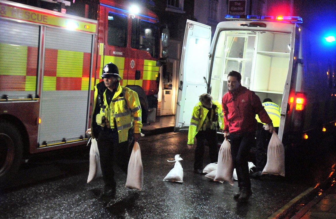 Teamwork: police and others work to help protect properties with sandbags. Photograph: Nigel Holland