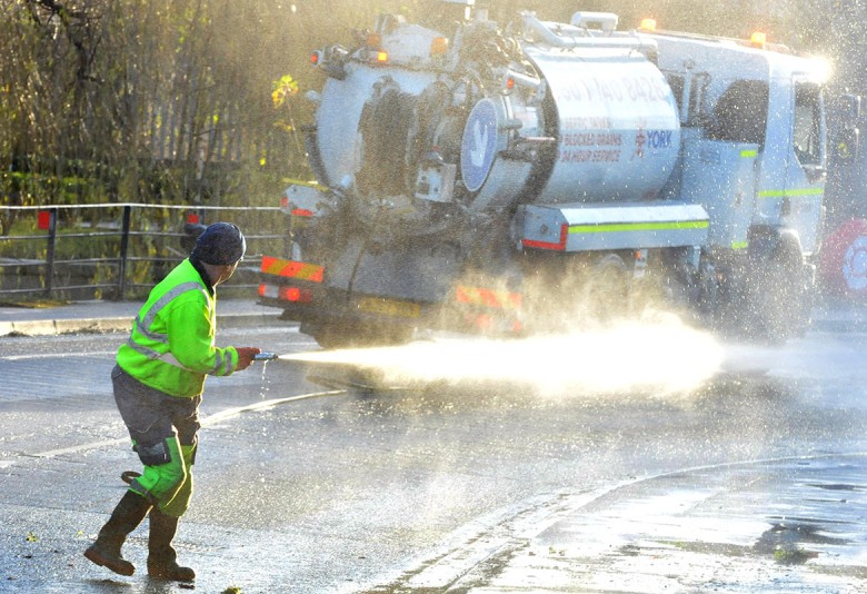 A council worker hoses down Foss Bank after the floodwaters recede. Photograph: Nigel Holland