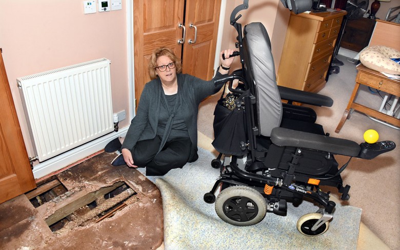 Liz with Tim's wheelchair and the damaged floor
