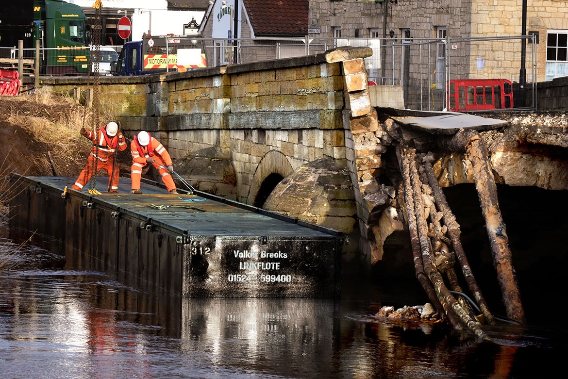 The pontoon is eased into place next to the remains of the bridge