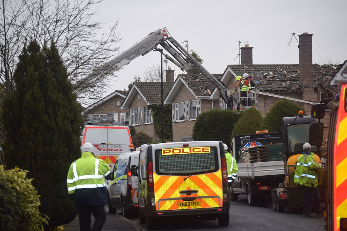 Firefighters and engineers examine the damage to one of the neighbouring houses. Photograph: Jack Gevertz