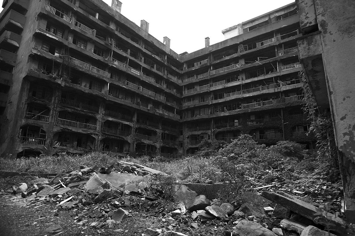 The rotting balconies of apartments overlooking some overgrown open space