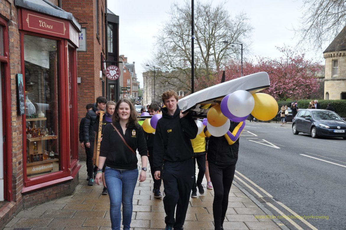 Festooned with balloons, the boat is taken from its waterside home through the York streets