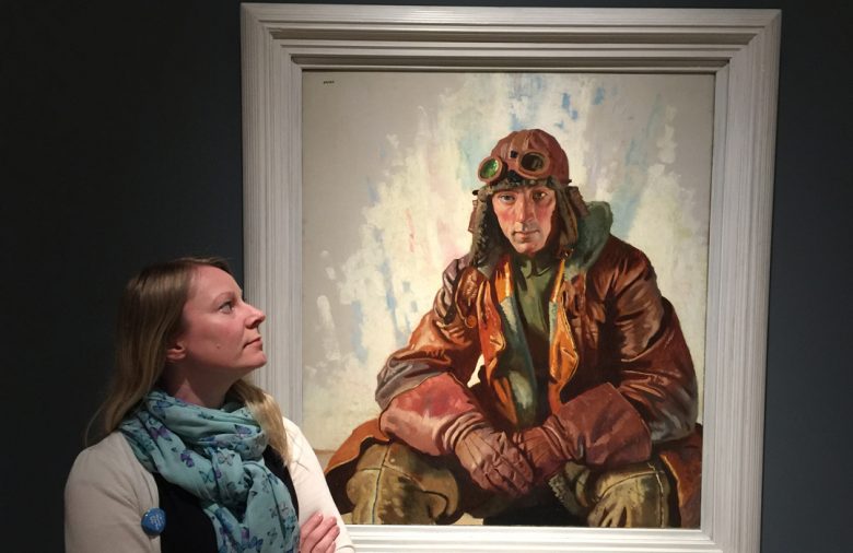 Assistant curator of art Lorna Hogger with The NCO Pilot by William Orpen. © IWM 