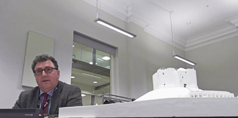 Cllr Hayes addressing the planning committee next to a model of the planned changes. Photograph: YouTube