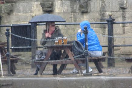 We’re not going to let a drop of rain spoil our pint! Hardy pair show true Yorkie spirit in downpour