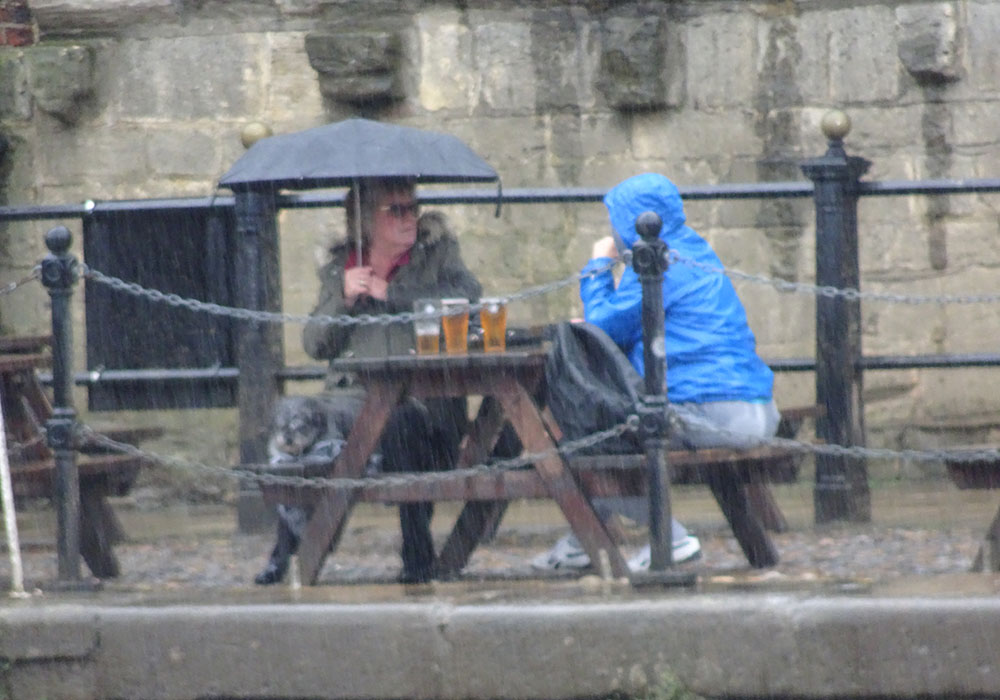 We’re not going to let a drop of rain spoil our pint! Hardy pair show true Yorkie spirit in downpour