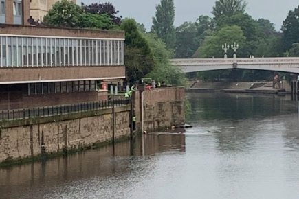 Police officers go into the River Ouse to rescue a man who was in the water