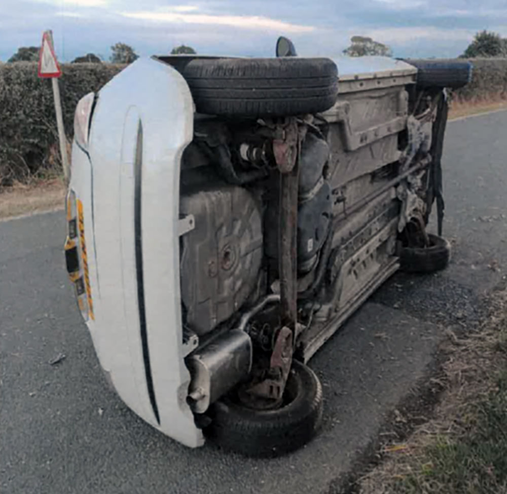 Driver flees after crash leaves car on its side