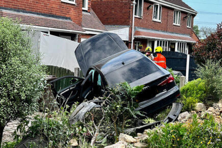 Car crashes into garden after two-vehicle collision