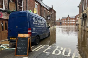 ‘Floody hell, it’s upstairs only’: Flood-hit York bar stays open and urges people to visit